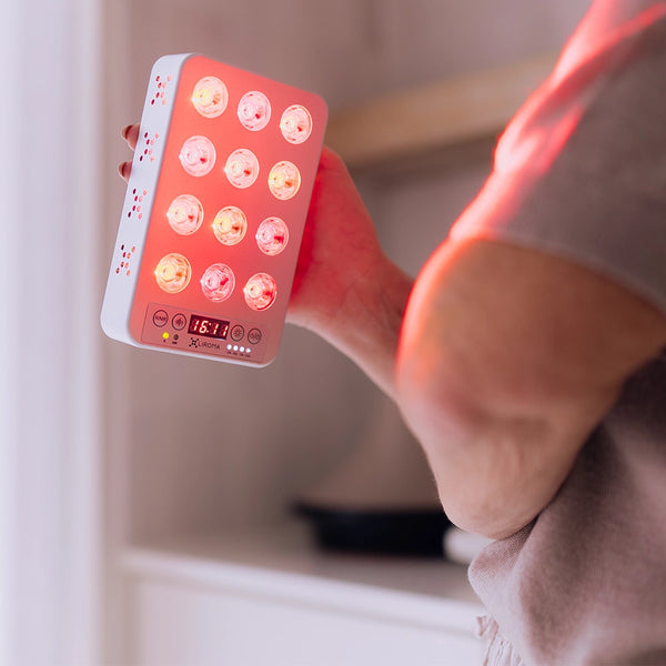 Liroma Portable Prime rood licht lamp op een elleboog